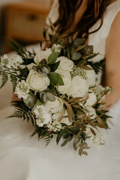 A bride holding a white rose bouquet.