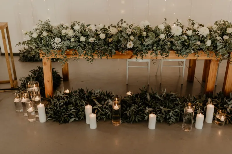 A eucalyptus and floral table setting with floating candles.