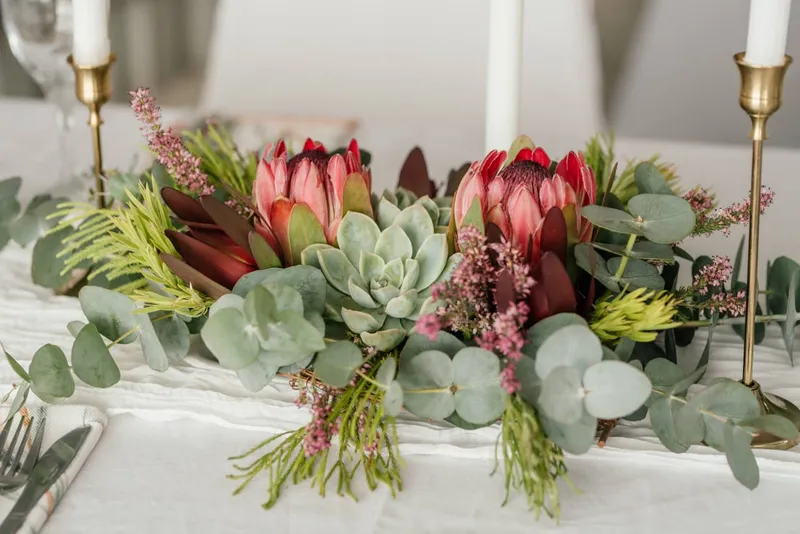 A red protea and succulent centerpiece arrangement.