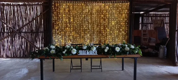 A rustic barn sweetheart table lit with fairy lights.