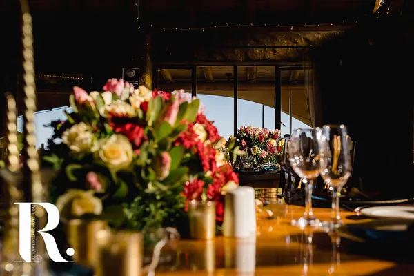 A rustic outdoor venue styled with floral centerpieces at dusk.