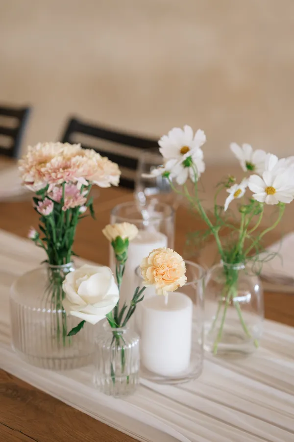 A bud vase arrangement styled beside a table number.