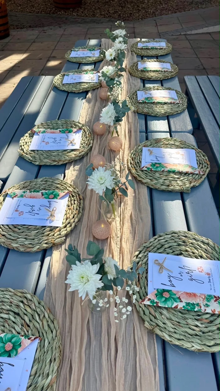 Woven placemats and an eucalyptus table runner styled on a reception table.